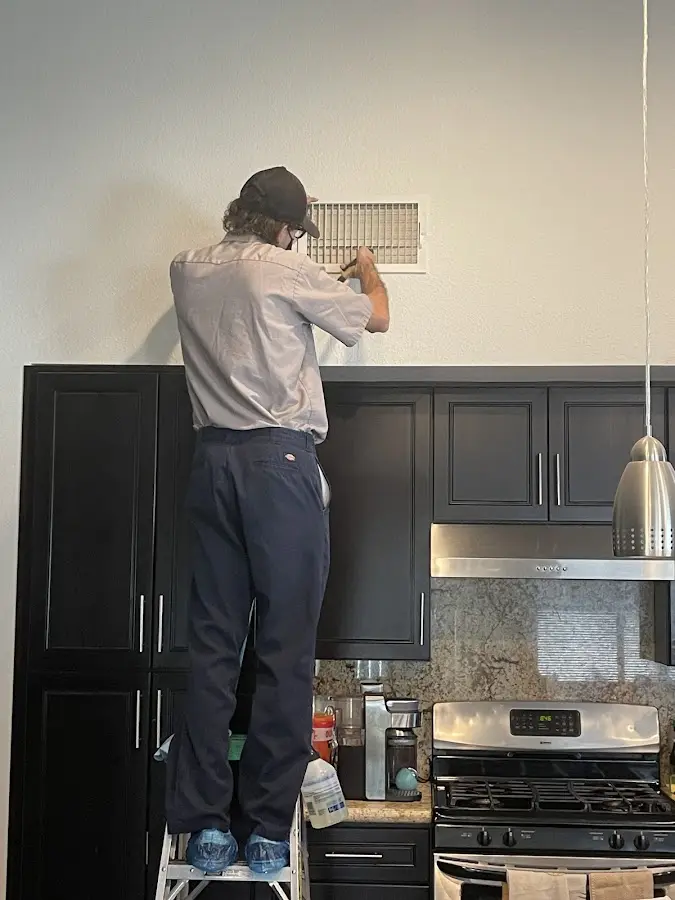 Technician inspecting an air vent during HVAC service in Riviera Beach